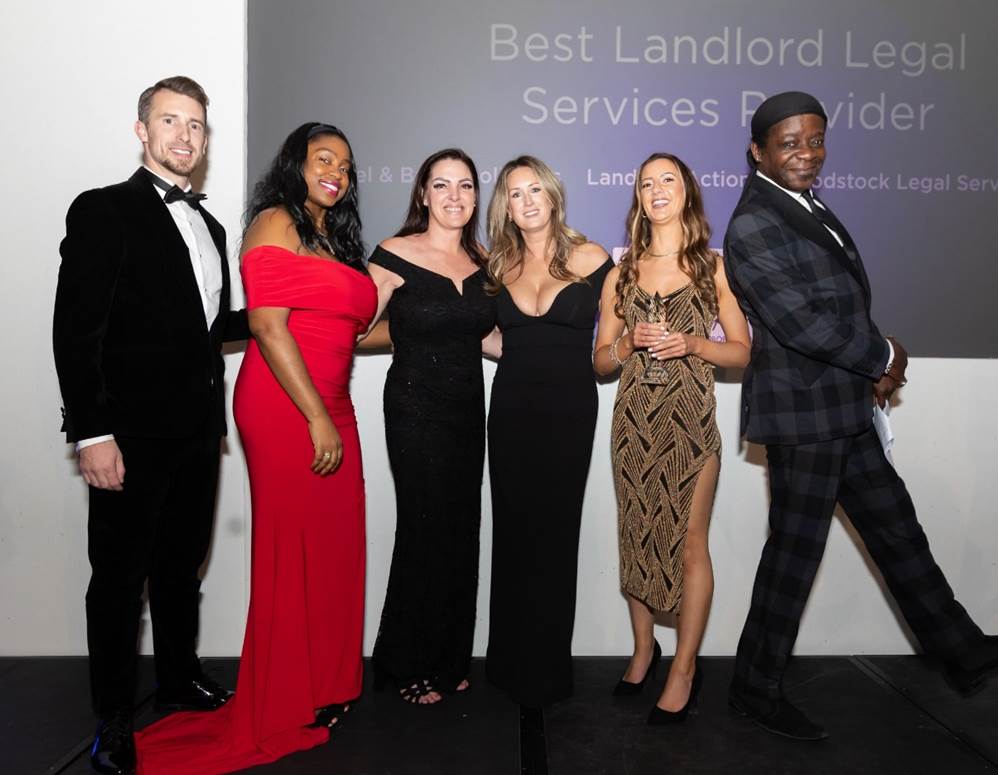 Left to right: Kane Andrews CEO of Rockstar Property (who presented the category award); April Cuffy, legal assistant; Natasha Boyland, head of operations and risk; Carly Jermyn, CEO; Anna Hughes, head of landlord & tenant (all of Woodstock legal services); and Stephen K Amos (comedian and actor who hosted the awards) - contributed